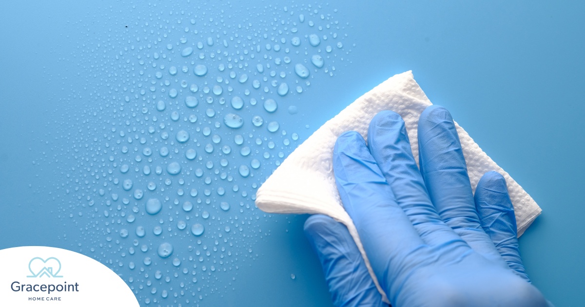 A gloved hand wipes down a surface, representing hygiene and practices that home health workers should employ.