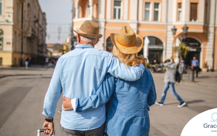 2 older adults hug while on vacation representing the successful outing that can still happen while caring for elderly loved ones.