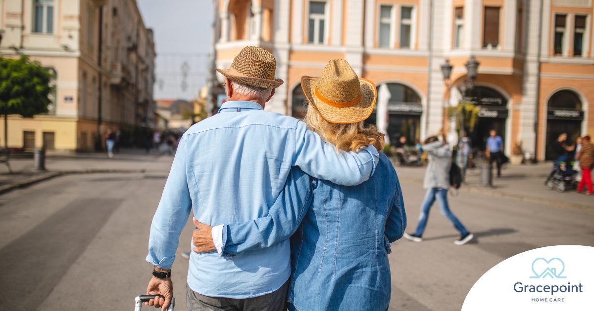 2 older adults hug while on vacation representing the successful outing that can still happen while caring for elderly loved ones.