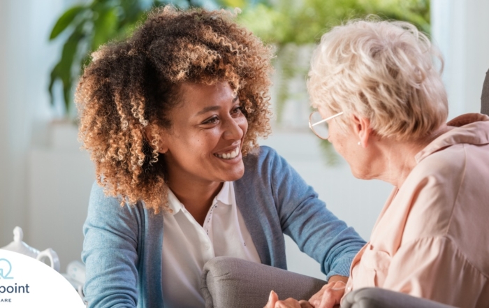 A caregiver warmly speaks with an older client, representing the quality communication that can come with bilingual care.