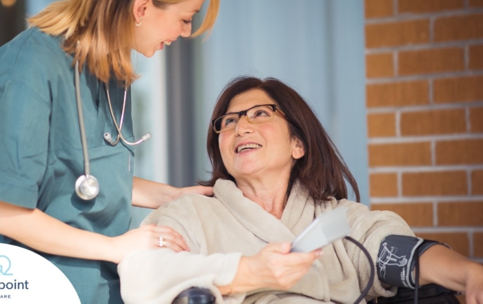 A care provider helps a patient in a wheelchair representing the benefits of medical care at home.