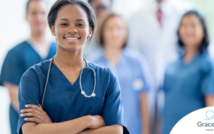 A woman in scrubs with a healthcare team behind her represents starting a new home health care job with a confident approach.