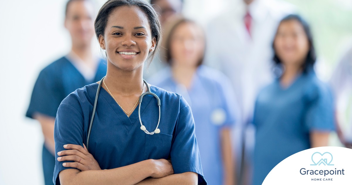 A woman in scrubs with a healthcare team behind her represents starting a new home health care job with a confident approach.