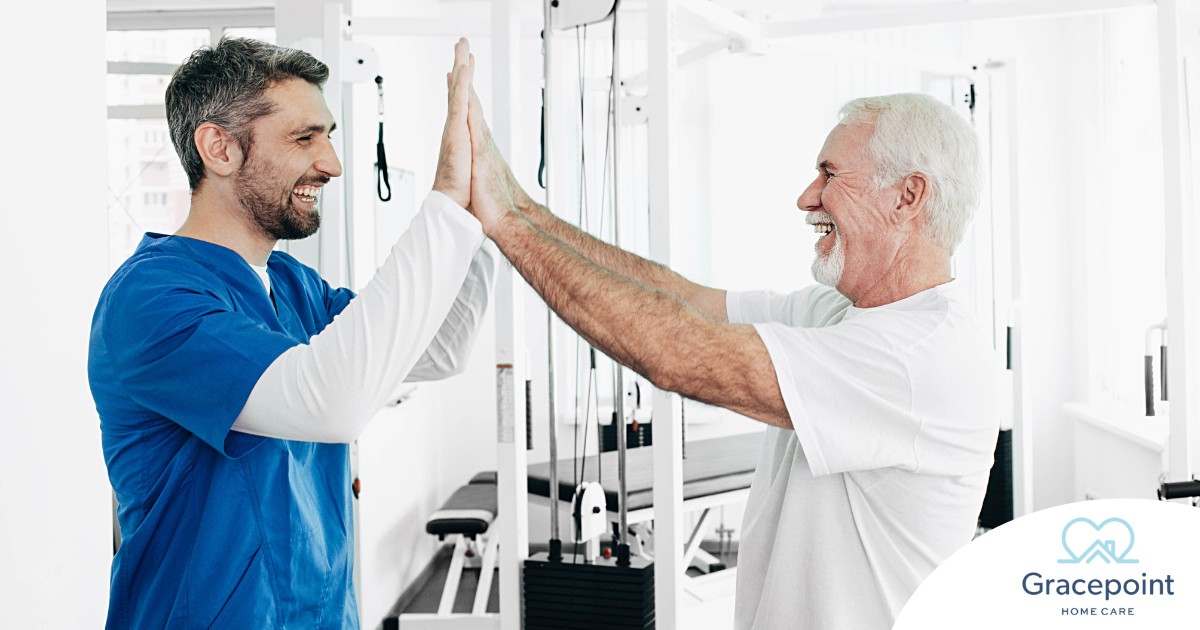 A healthcare worker and patient smile and high five representing the satisfaction that can come from a career as a physical therapy assistant.