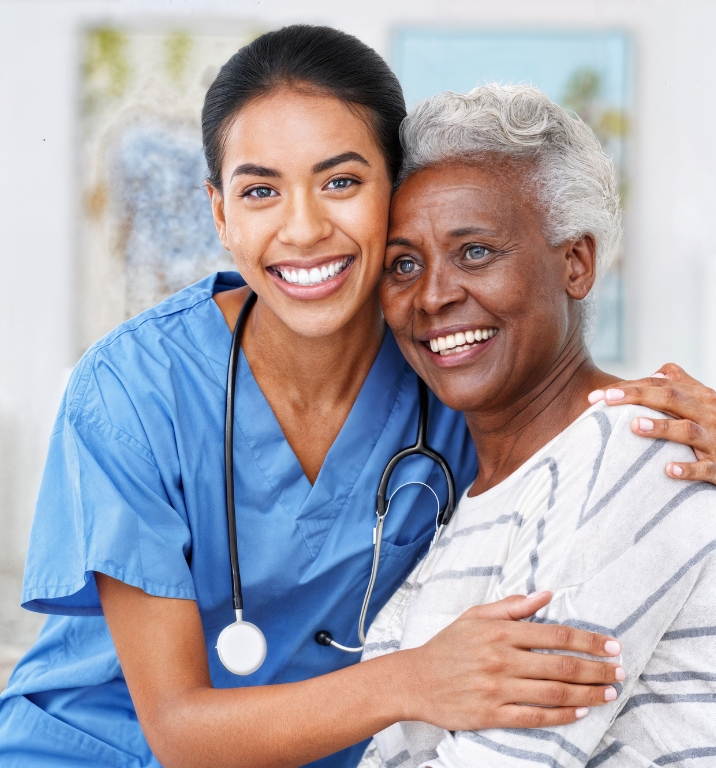 Add-on Nursing Support Services A smiling nurse in blue scrubs providing Add-on Nursing Support Services while hugging a happy senior woman, showing warmth, care, and compassion.